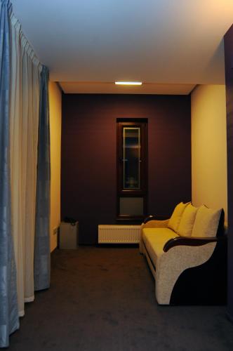 a bedroom with a bed with yellow pillows and a window at Hotel Diafan in Baia Mare