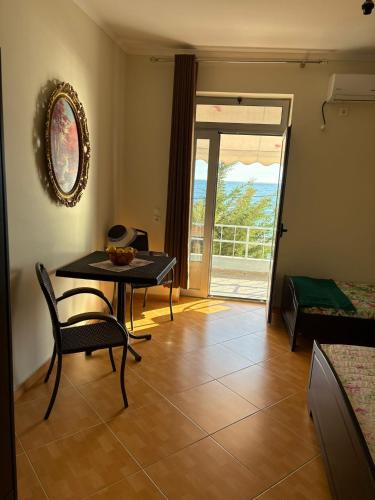 a living room with a table and chairs and a door at Al Mare Borsh in Borsh