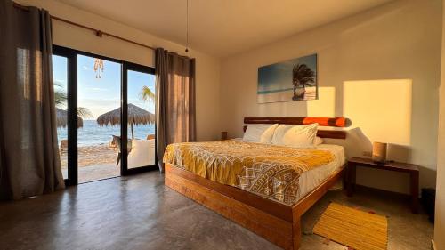 a bedroom with a bed and a view of the beach at Baja Canoas Hotel in Canoas De Punta Sal