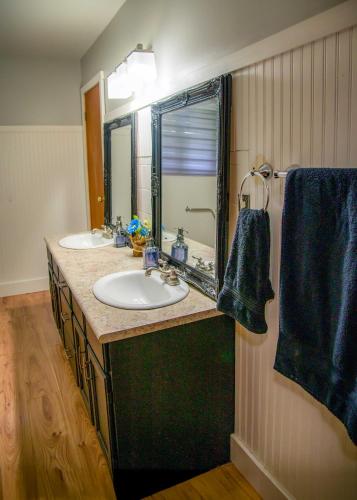 a bathroom with two sinks and a large mirror at Petals Suite Patio Nature Trails Bancroft in Bancroft