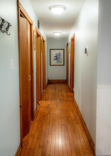 a hallway with wooden floors and wooden doors at Petals Suite Patio Nature Trails Bancroft in Bancroft