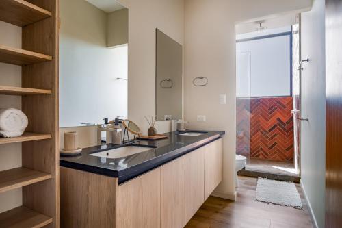 un baño con lavabo y ducha en Wave House, en El Zonte
