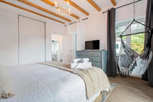 a bedroom with a swinging bed and a tv at Villa Pomar, By OP in Senhora do Rosário