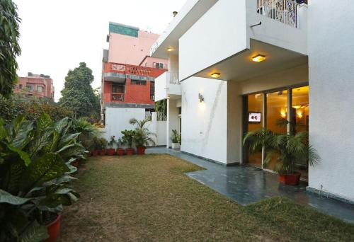 a courtyard of a white building with plants at Hotel O Gem 92 in New Delhi