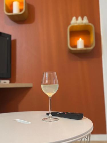 a glass of white wine sitting on a table at DaxLodge T3 cosy in Dax