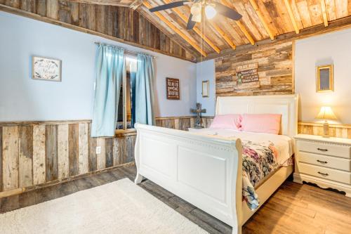 a bedroom with a bed and a wooden wall at Walk to Lake Buchanan Cottage Near Wineries! in Buchanan Dam
