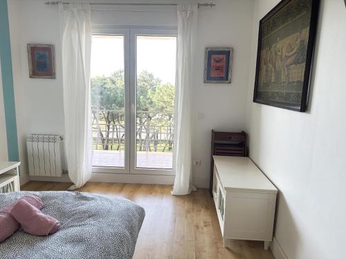 a bedroom with a bed and a large window at Apartamento en la playa de Mogro con parking privado in Mogro