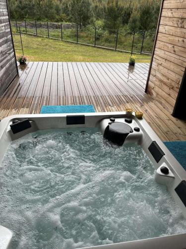 une baignoire jacuzzi sur une terrasse en bois dans l'établissement Beautiful house with a hot tub and garden, à Bias