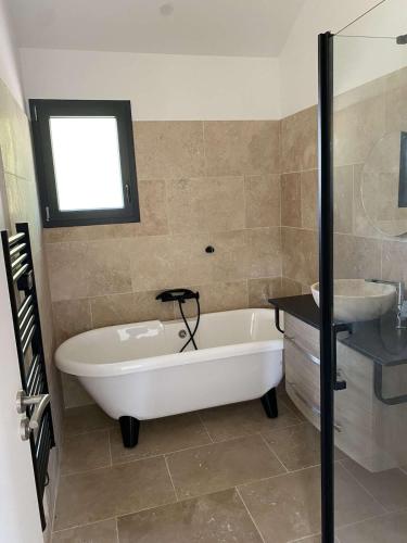 une salle de bain avec une baignoire et un lavabo dans l'établissement Beautiful house with a hot tub and garden, à Bias