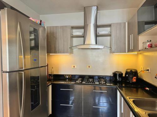 a kitchen with a stainless steel refrigerator and a sink at Pavilhão Egípcio in Curitiba