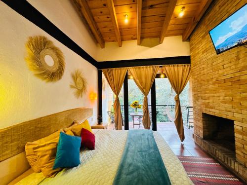 a bedroom with a bed with colorful pillows and a fireplace at Encino House Hotel Boutique in Valle de Bravo