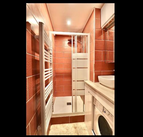 une salle de bain avec un lavabo et une machine à laver dans l'établissement Beautiful 3 rooms in a serviced apartment, à Paris