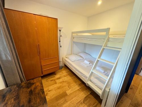 Cette petite chambre comprend des lits superposés et une armoire. dans l'établissement Beautiful 3 rooms in a serviced apartment, à Paris