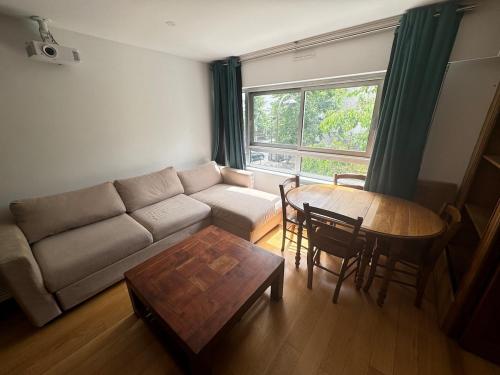 un salon avec un canapé et une table dans l'établissement Beautiful 3 rooms in a serviced apartment, à Paris