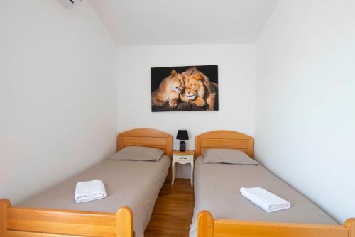 two beds in a room with a picture of a lion at Vacation villa Matic with 7 bedrooms in Sinj