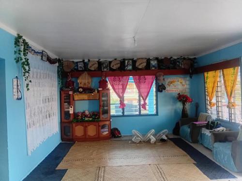 a living room with blue walls and windows at Save's Homestay in Nadi