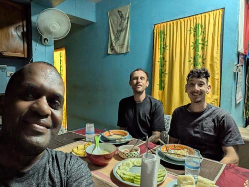 a group of three men sitting at a table with food at Save's Homestay in Nadi
