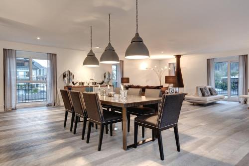 une salle à manger et un salon avec une table et des chaises dans l'établissement Penthouse Le Lustre, à Chamonix-Mont-Blanc