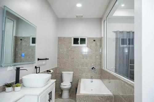 a bathroom with a sink and a toilet and a tub at The Royal Haven Herstelling, Georgetown in Nismes