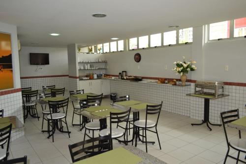 um restaurante com mesas e cadeiras e uma cozinha em Hotel Ideal em Teresina