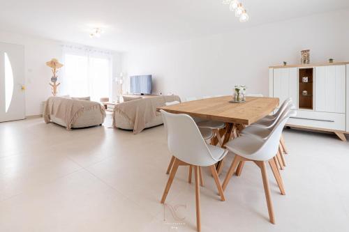 une salle à manger avec une table en bois et des chaises blanches dans l'établissement Dream house Disneyland Paris, à Montévrain