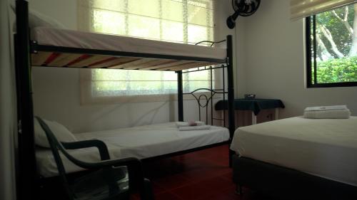 a bedroom with two bunk beds and a window at Casa finca La alegría - casa el Recreo in La Mesa
