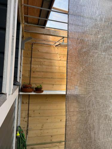 une vue extérieure d'une pergola avec un mur en bois dans l'établissement Surf Camp, à Saint-Lunaire