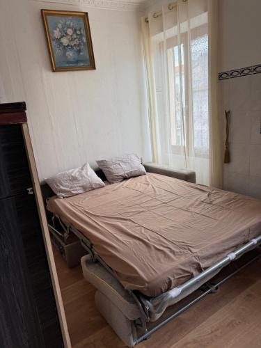 - un lit vide dans une chambre avec fenêtre dans l'établissement Daghsen, à Nice