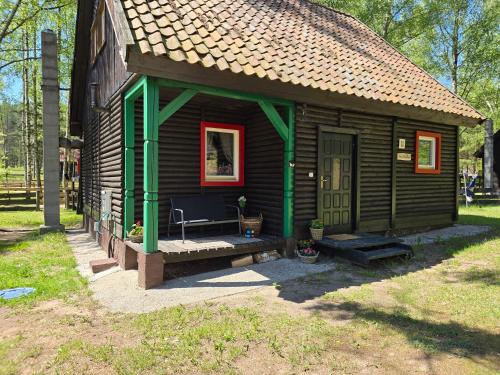 una piccola cabina con panchina di fronte di Na Zboczu - Rodzinny Domek w Lesie na Mazurach z Basenem i Sauną a Guzowy Piec