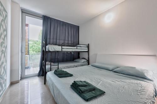 a bedroom with a bed with two bunk beds at Magnolie A47, 6 posti vicino al mare in Eraclea Mare