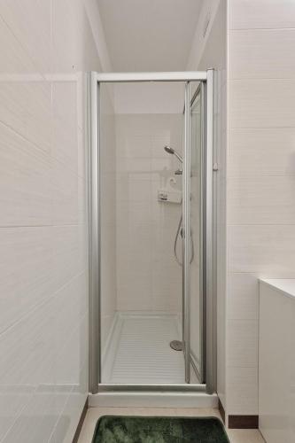 a shower stall in a bathroom with a green rug at Magnolie A47, 6 posti vicino al mare in Eraclea Mare
