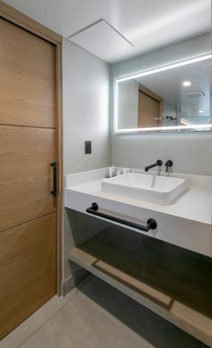 a bathroom with a sink and a mirror at La Jolla Cove Suites in San Diego