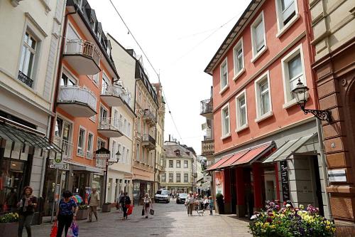 a group of people walking down a street with buildings at Vip Apartment an den Thermen in Baden-Baden