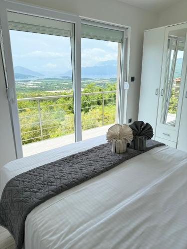 a bedroom with a large bed with a large window at Sisters residence in Kotor