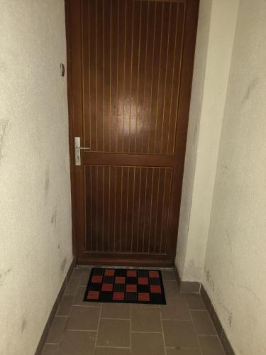 une porte en bois avec un sol en damier devant elle dans l'établissement Appartement Jelyad Stade, à Lagny-sur-Marne