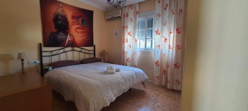 a bedroom with a bed and a painting on the wall at Rooms Tourist Apartment in Huelva