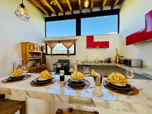 a kitchen with a table with yellow napkins and glasses at Encino House Hotel Boutique in Valle de Bravo