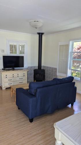 a living room with a blue couch and a stove at Tomales Bay Lodge and Marina Inc in Inverness