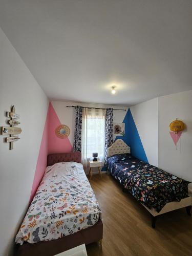 une chambre avec deux lits et une fenêtre dans l'établissement Cozy Family, à Angers