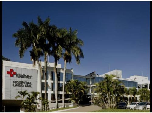 een ziekenhuis met palmbomen voor een gebouw bij Lago sul - Daher in Brasilia