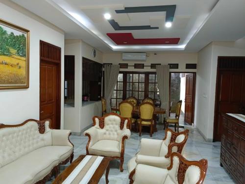 a living room with white furniture and a table at Siloyo Homestay - Hommy place to stay! in Sasak Dua