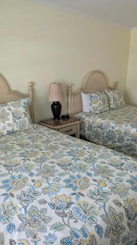 a bedroom with two beds and a table with a lamp at Tomales Bay Lodge and Marina Inc in Inverness