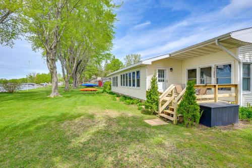 a house with a yard next to a building at Shawano Lake House with Boat Dock, Kayaks, and Grill! in Shawano