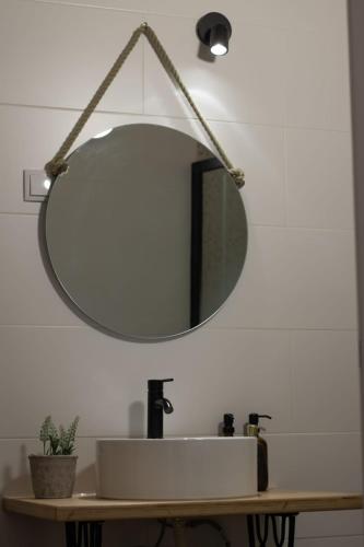a bathroom sink with a large mirror on the wall at Alqueive GUEST HOUSE in Alqueva