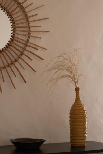 a vase sitting on a table next to a mirror at Alqueive GUEST HOUSE in Alqueva