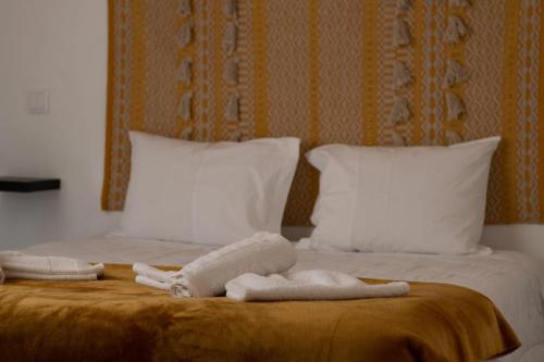 two towels on a bed with two pillows at Alqueive GUEST HOUSE in Alqueva