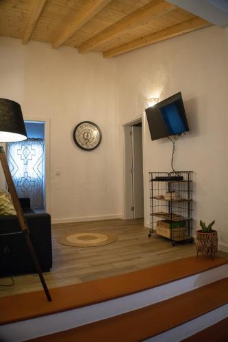 a living room with a flat screen tv on a wall at Alqueive GUEST HOUSE in Alqueva