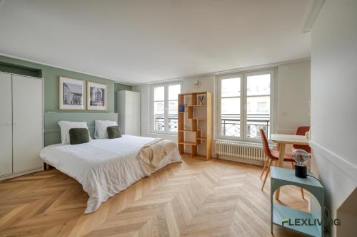 une chambre avec un lit, un bureau et des fenêtres dans l'établissement Beautiful Studio - Chauchat - Flexliving, à Paris