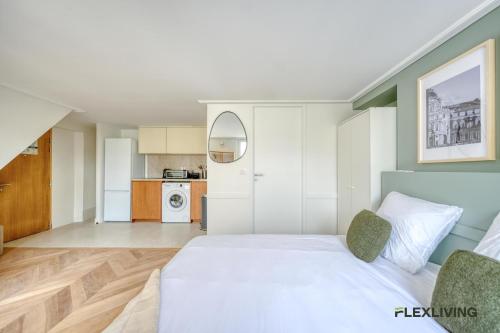 Cet appartement comprend une chambre avec un lit blanc et une cuisine. dans l'établissement Beautiful Studio - Chauchat - Flexliving, à Paris