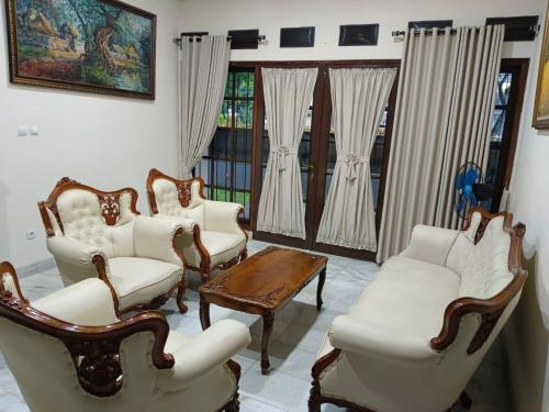 a living room with chairs and a table and windows at Siloyo Homestay - Hommy place to stay! in Sasak Dua